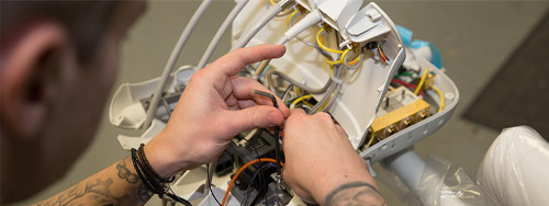 Dental engineer working on wiring inside an A-dec delivery system